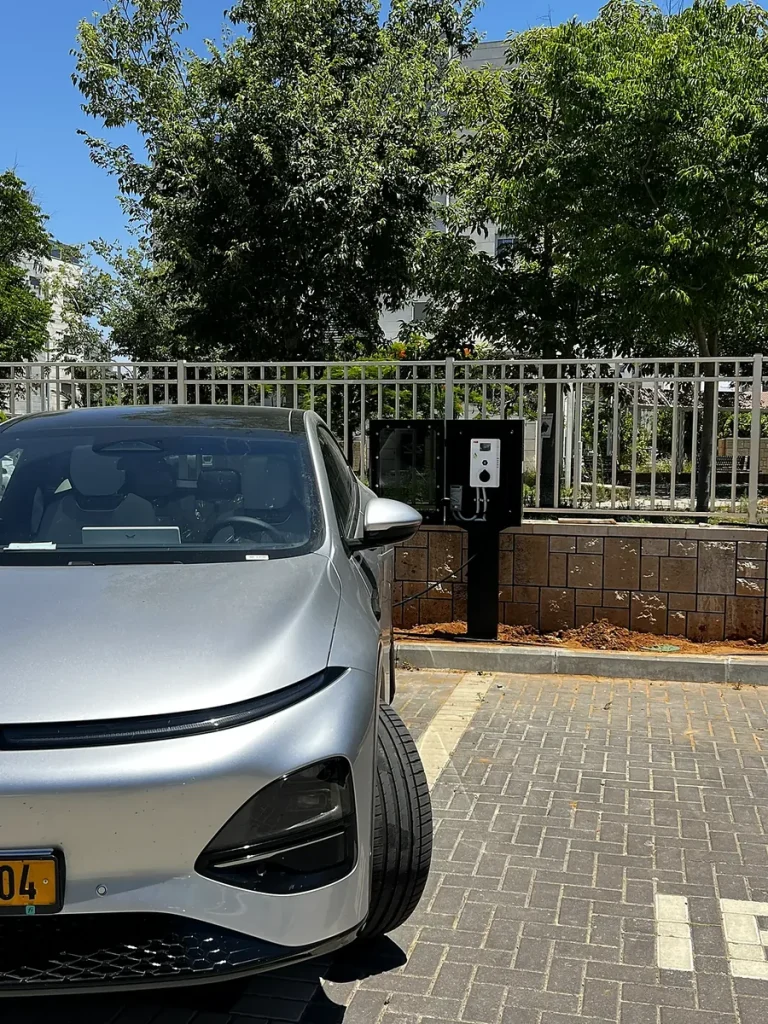 עמדת טעינה לרכב חשמלי בחניה מול רכב חשמלי